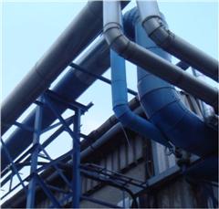 Blue insulated steam distribution piping running along an outdoor industrial structure.